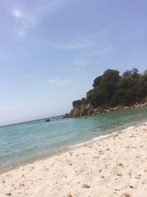 A beach with clear turquoise water, sandy shore, and rocky cliffs with greenery. - Duplex apartment for 4 people, 5 minutes from the beach and shops, PORTICCIO Center (Porticcio)