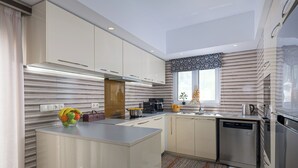 Una cocina moderna con una isla central, electrodomésticos de acero inoxidable y un ventanal con vistas.