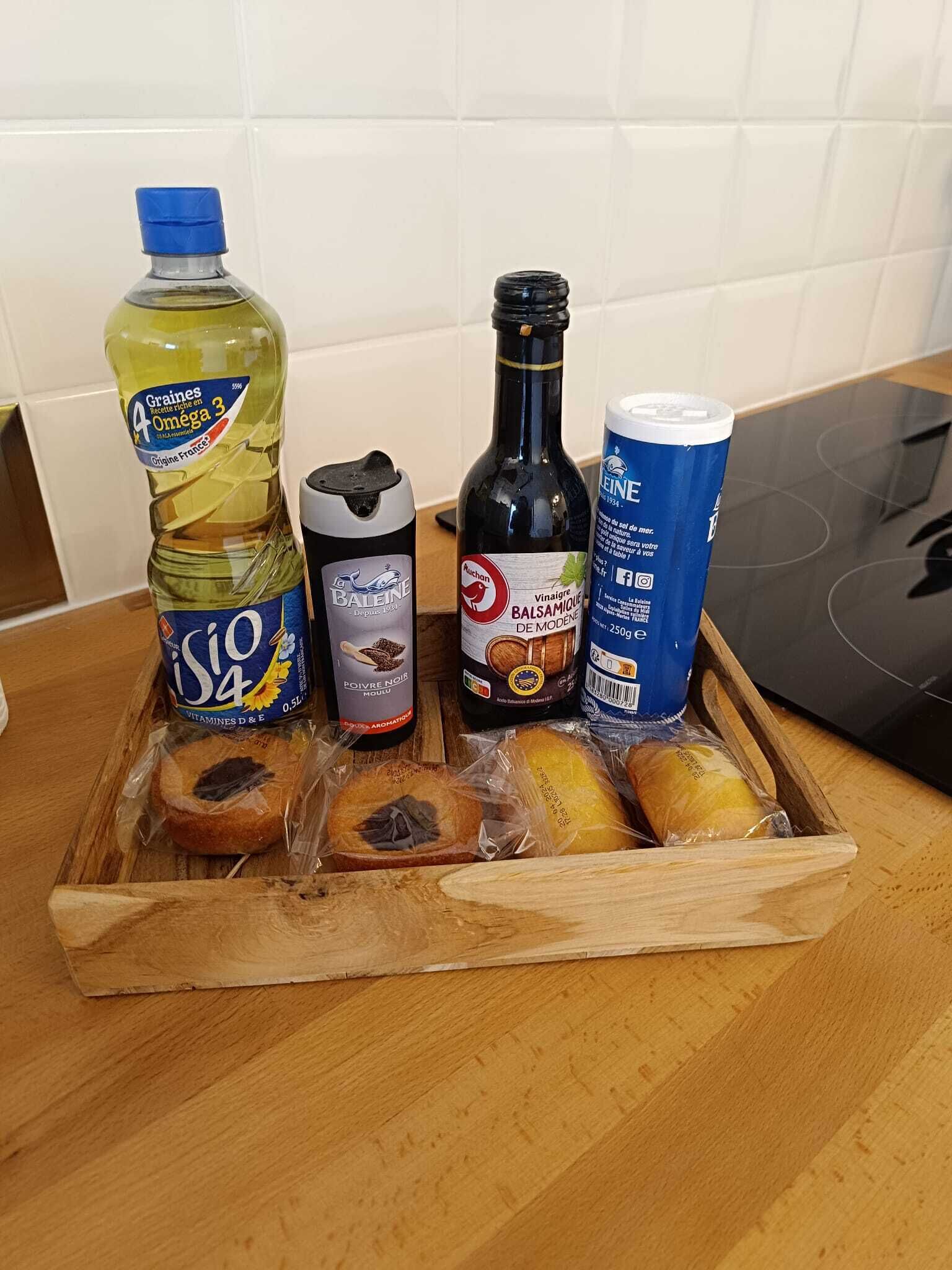 Una bandeja de madera con diversos alimentos y botellas sobre una encimera de cocina.