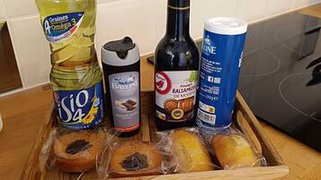 Una bandeja de madera con diversos alimentos y botellas sobre una encimera de cocina.