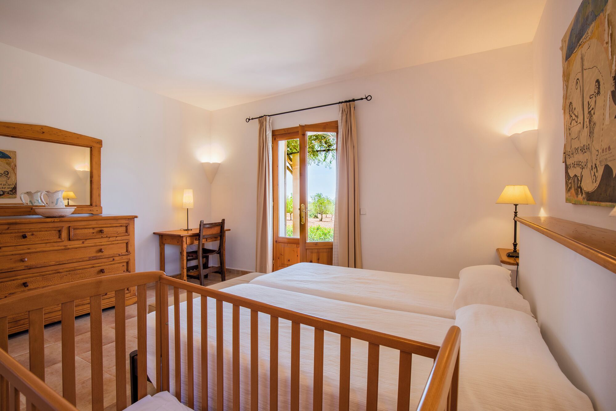 Un dormitorio con dos camas, un aparador de madera, un escritorio y una silla.