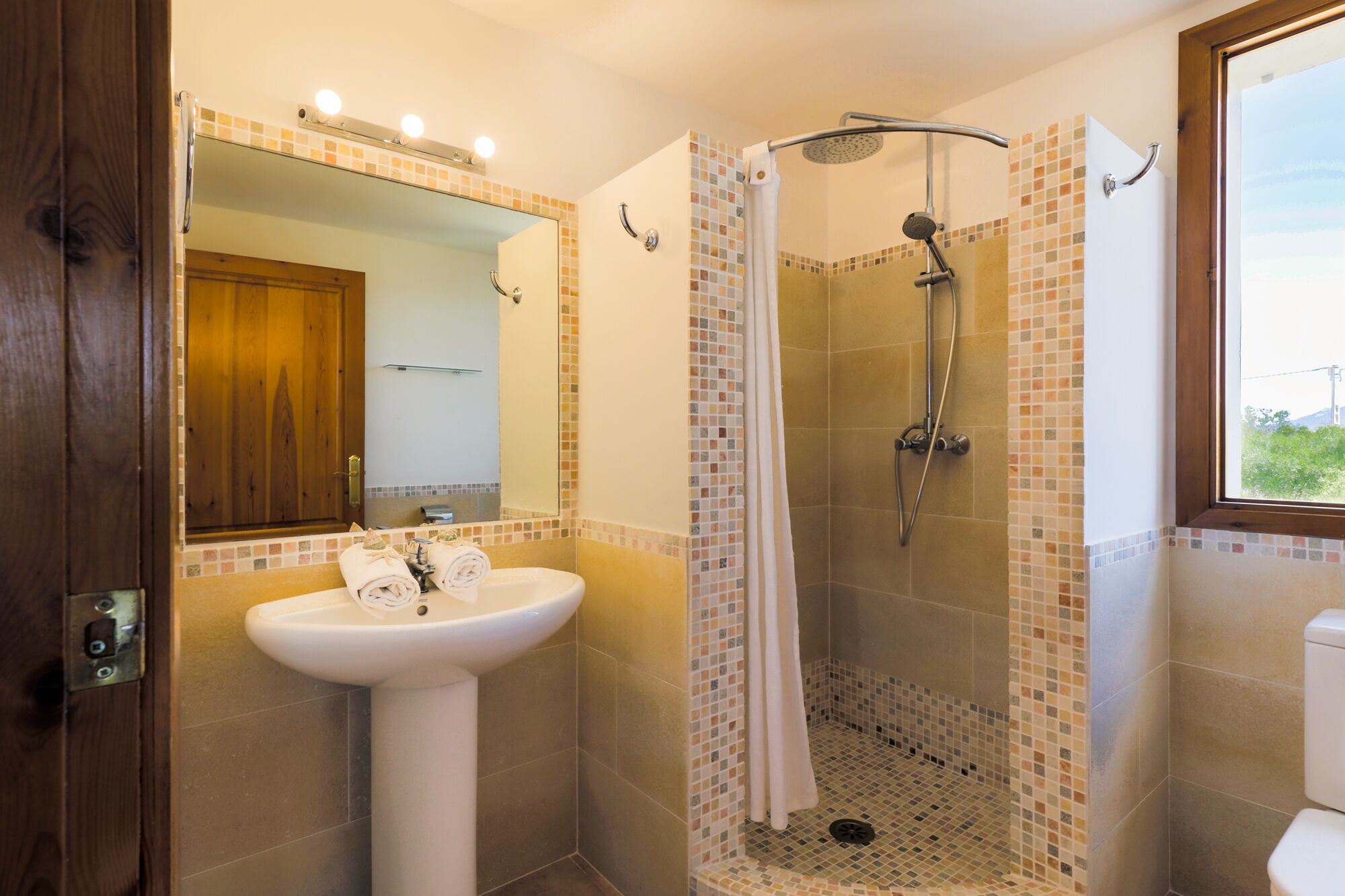A bathroom with a white sink, a shower with a glass door, and a mirror above the sink.