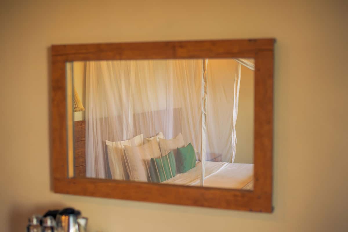 A bed with a canopy, pillows, and a wooden frame.
