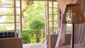 A room with large windows, a bed, and a hanging lamp.