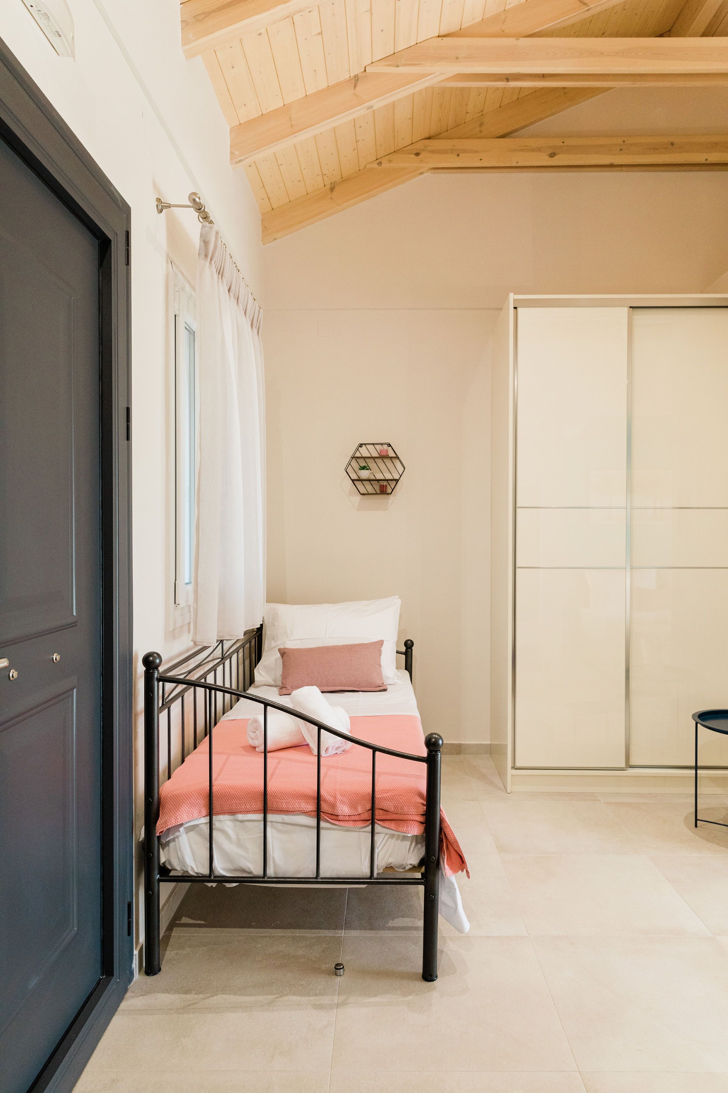 A bedroom with a bed, a wardrobe, and a door.