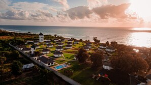 A coastal resort with white buildings, a central tower, and a swimming pool. - Aya Sophia Villa Garden Hotel (Kutani)