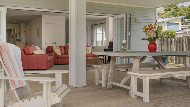 A spacious living area with a red sofa, a white table, and a wooden bench.