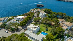 Un quartier résidentiel situé sur la côte, avec des maisons, une piscine et une vue sur la mer.