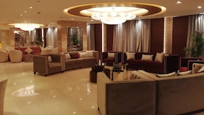 A spacious, well-lit lobby with a large, circular chandelier, plush seating arrangements, and a polished marble floor. - Cairo Taj Hotels & Suites - Dokki (Giza)