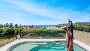 A pool area with a view of the ocean and surrounding buildings. - Sapphire on Wilson, Gerringong (Gerringong)