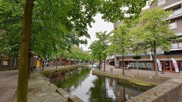 A canal lined with trees and buildings, with a bike parked by the water.