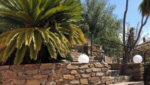 A stone staircase with steps leading up to a stone wall, surrounded by palm trees and a clear sky. - Villa with superb sea view, swimming pool, 350 metres from the beach, air conditioning, garden (LE LAVANDOU)