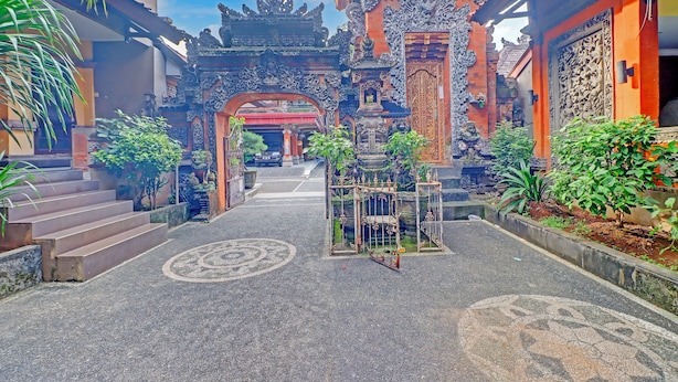 Un temple balinais traditionnel, doté d’une architecture richement décorée, d’une porte principale et d’un chemin menant à l’entrée principale.