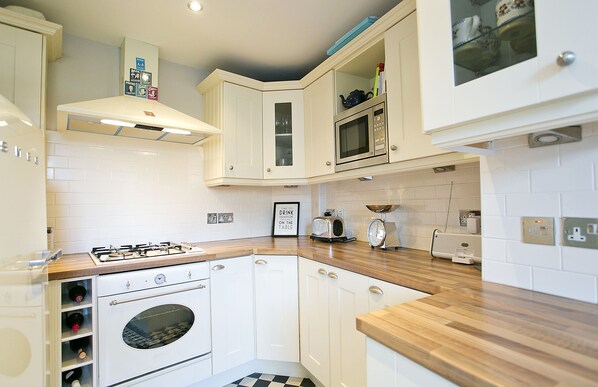 Enjoy cooking in this well-equipped kitchen with a gas stove, oven, microwave, and toaster.