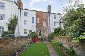Stroll through the serene courtyard, surrounded by lush greenery and brick pathways.