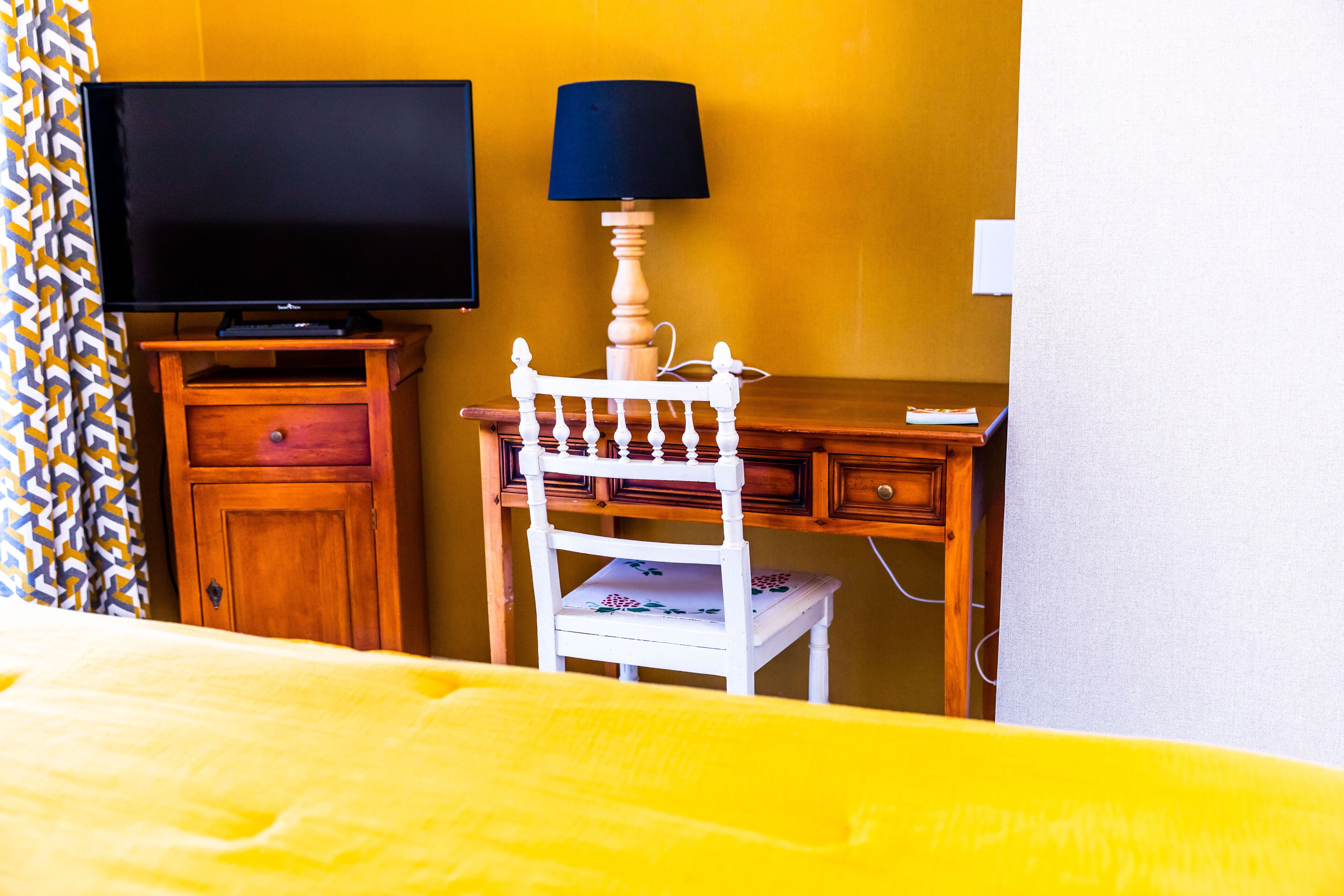 Une chambre d’hôtel équipée d’un lit, d’une télévision, d’un bureau et d’une chaise.