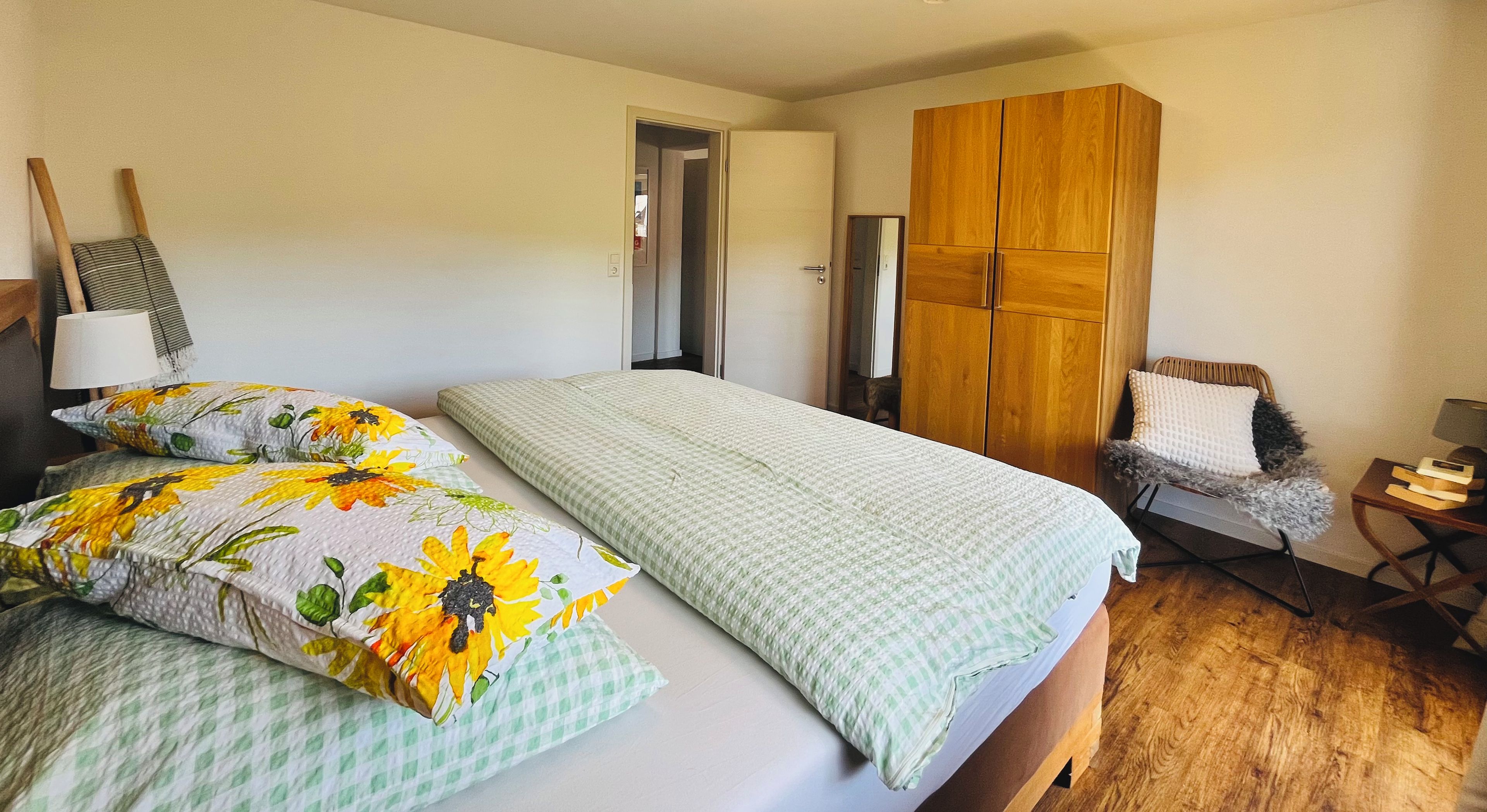 Una camera da letto con un letto, un armadio, una sedia e un comodino.