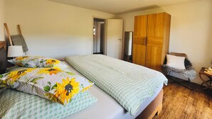 A bedroom with a bed, a wardrobe, a chair, and a nightstand. - Recreation resort for Black Forest fans (Horben)