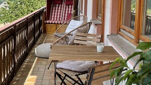 A balcony with wicker furniture, a cushioned chair, and a table with a glass of milk. - Recreation resort for Black Forest fans (Horben)