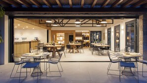 An indoor dining area with tables and chairs, a reception desk, and a wine display. - Quinta San Francisco (Castrojeriz)