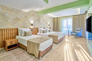A hotel room with two beds, a TV, a chair, and a wooden nightstand. - DER INN LARA (Antalya)