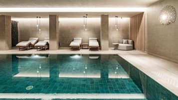 Una piscina cubierta, una piscina al aire libre, sombrillas, tumbonas