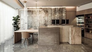 A modern kitchen with a marble countertop, wooden cabinets, and a built-in wine cooler.