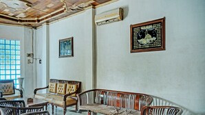A room with a traditional wooden ceiling, a sofa set, and a patterned rug. - Hotel O Romli (Kayu Agung)