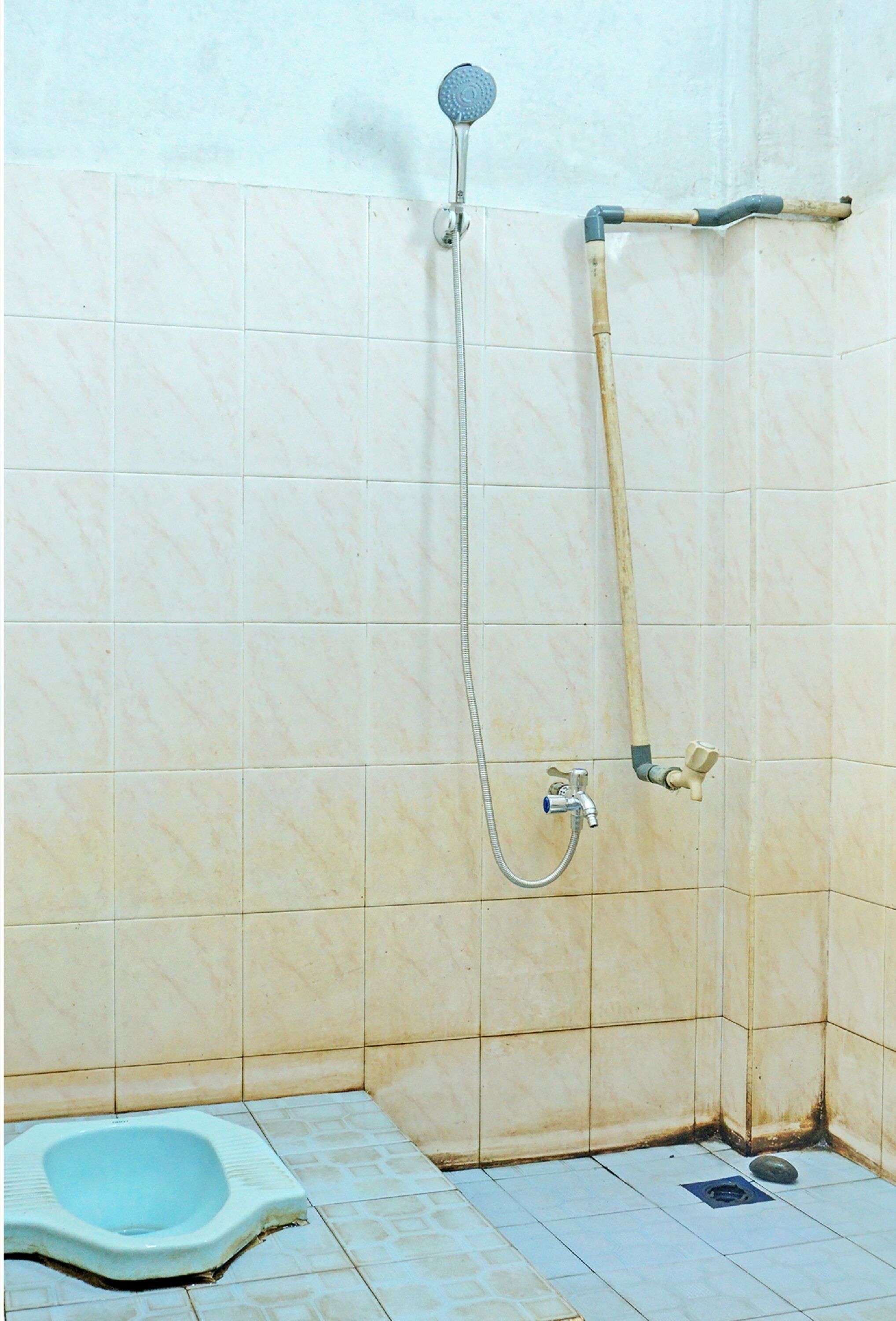 A small bathroom with a shower, a toilet, and tiled walls.