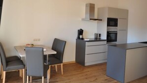 Una cucina moderna con zona pranzo, caratterizzata da un'isola centrale, elettrodomestici integrati e un design minimalista.