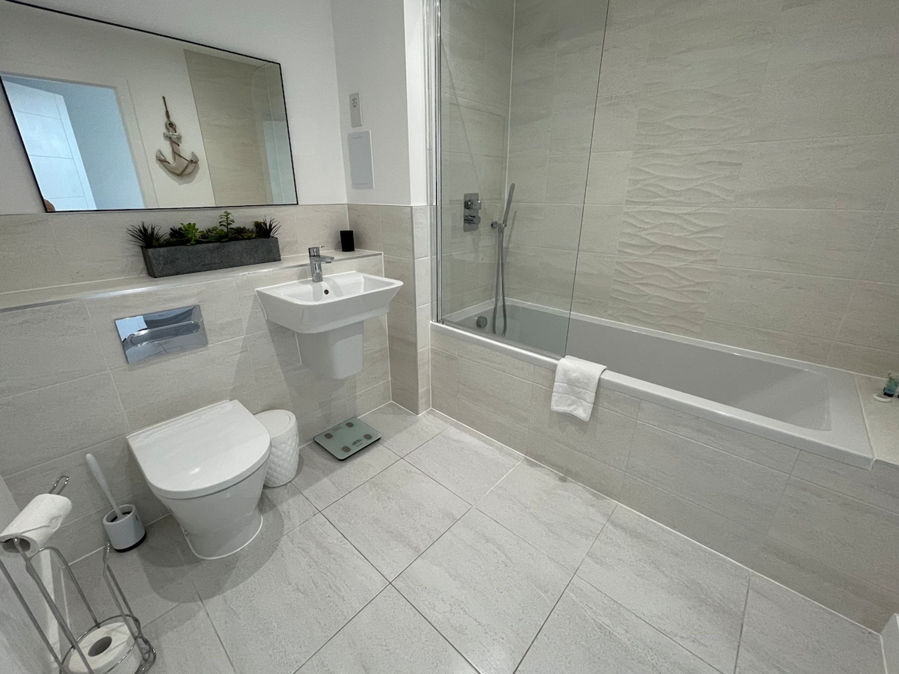 A modern bathroom with a toilet, sink, and shower.