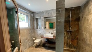 Un baño moderno con ducha, inodoro y lavamanos.