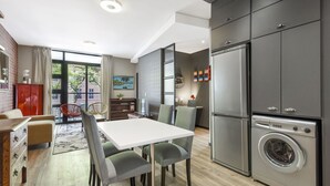 Een moderne keuken met grijze kastjes, een roestvrijstalen koelkast en een ingebouwde wasmachine.