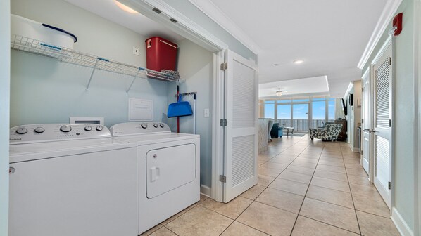 A laundry area with a washer and dryer, a red storage bin, and a blue mop. - Parking Level!! New to Rental Market!! Lazy River/Slide!! (Orange Beach)