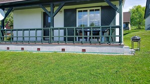 A building with a porch, a covered outdoor seating area, and a barbecue grill. - Holiday Hill 56 by Interhome (Cerny Dul/Cista)