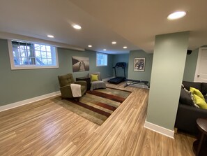 Relax in this inviting room with a comfortable armchair, treadmill, and natural views.