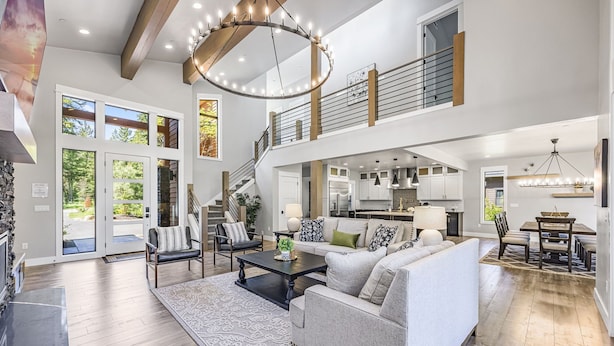 Ein geräumiger Wohnbereich mit Sofa, Couchtisch und einer Treppe zu einer oberen Ebene.