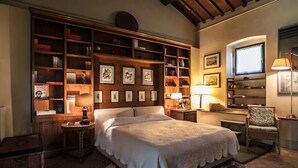Une chambre confortable avec un grand lit, des étagères en bois, un bureau et une chaise.