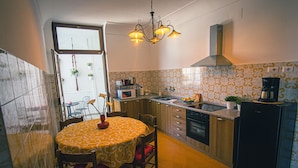 Cocina compacta con comedor, que incluye microondas, estufa y cafetera.