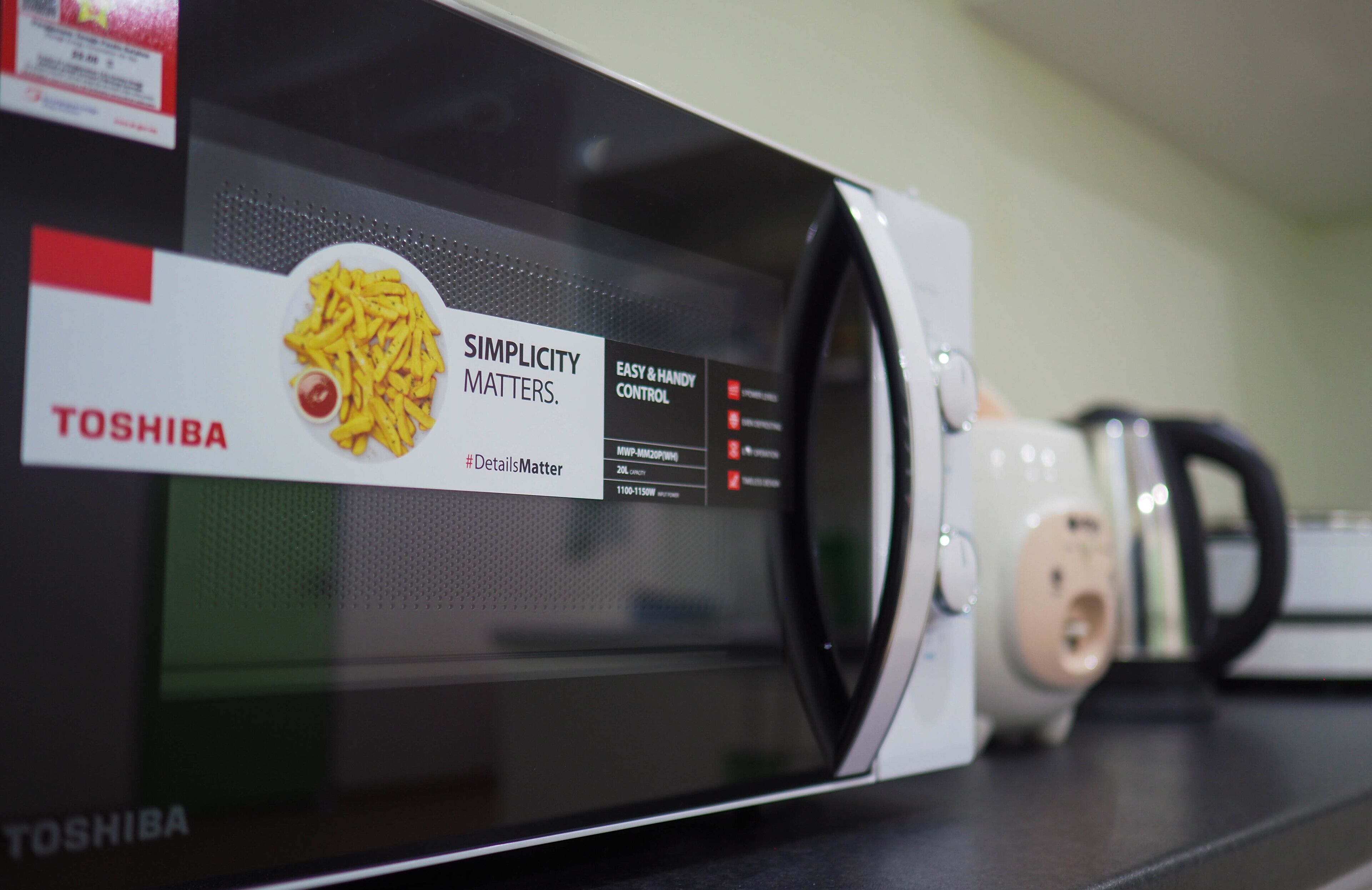 A microwave with a label that reads "Simplicity Matters" and "TOSHIBA" on the front.