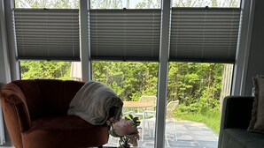 Een moderne woonkamer met een ronde marmeren salontafel, een bruine leren bank en een groene sofa.