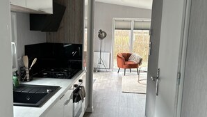Een moderne keuken met witte kasten, een zwart fornuis en een groot raam.
