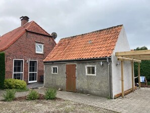 A small, single-story building with a red-tiled roof and a brick facade.