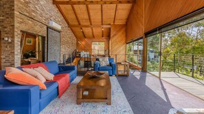 Relax in this spacious room with a sofa set, coffee table, and large windows offering a view of the outdoors.