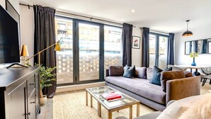 Ein modernes Wohnzimmer mit einer Couch, einem Couchtisch und einem Fernseher.