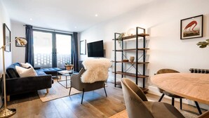 A modern living room with a sofa, armchair, and dining table.