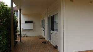 Enjoy the serene garden setting adjacent to the building, featuring a brick floor and lush greenery.