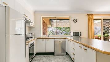 Enjoy cooking in this well-equipped kitchen with a refrigerator, oven, dishwasher, and microwave.