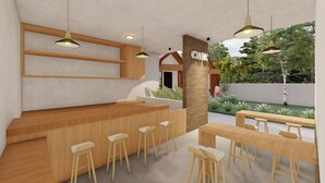 Um café moderno ao ar livre, com mobiliário de madeira, balcão e luminárias pendentes.