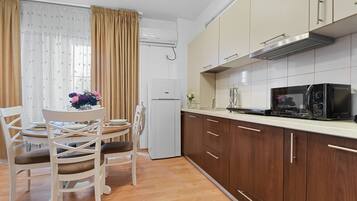 Familie appartement | Privékeuken | Een koelkast met diepvriezer, een microgolfoven, een oven